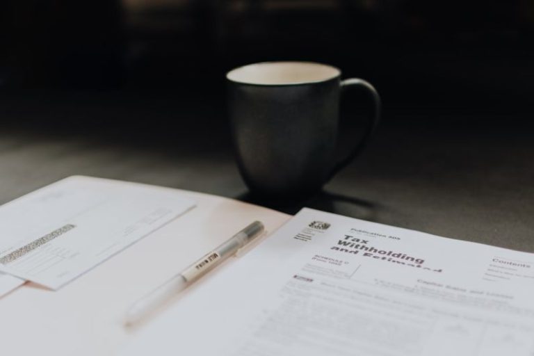 Taxes - coffee mug near open folder with tax withholding paper