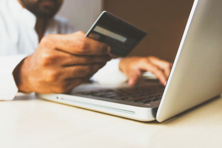 Payments - person using laptop computer holding card